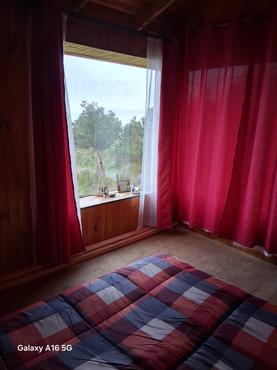 Habitación con ventana y cama roja azul